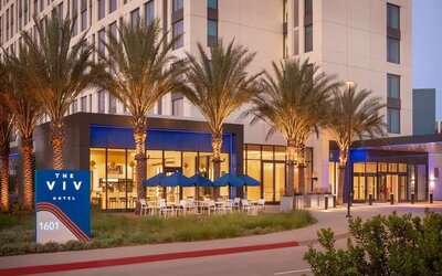 Exterior view of The Viv Hotel, Anaheim, A Tribute Portfolio Hotel showcasing its contemporary architecture, landscaped entrance, and welcoming arrival area.