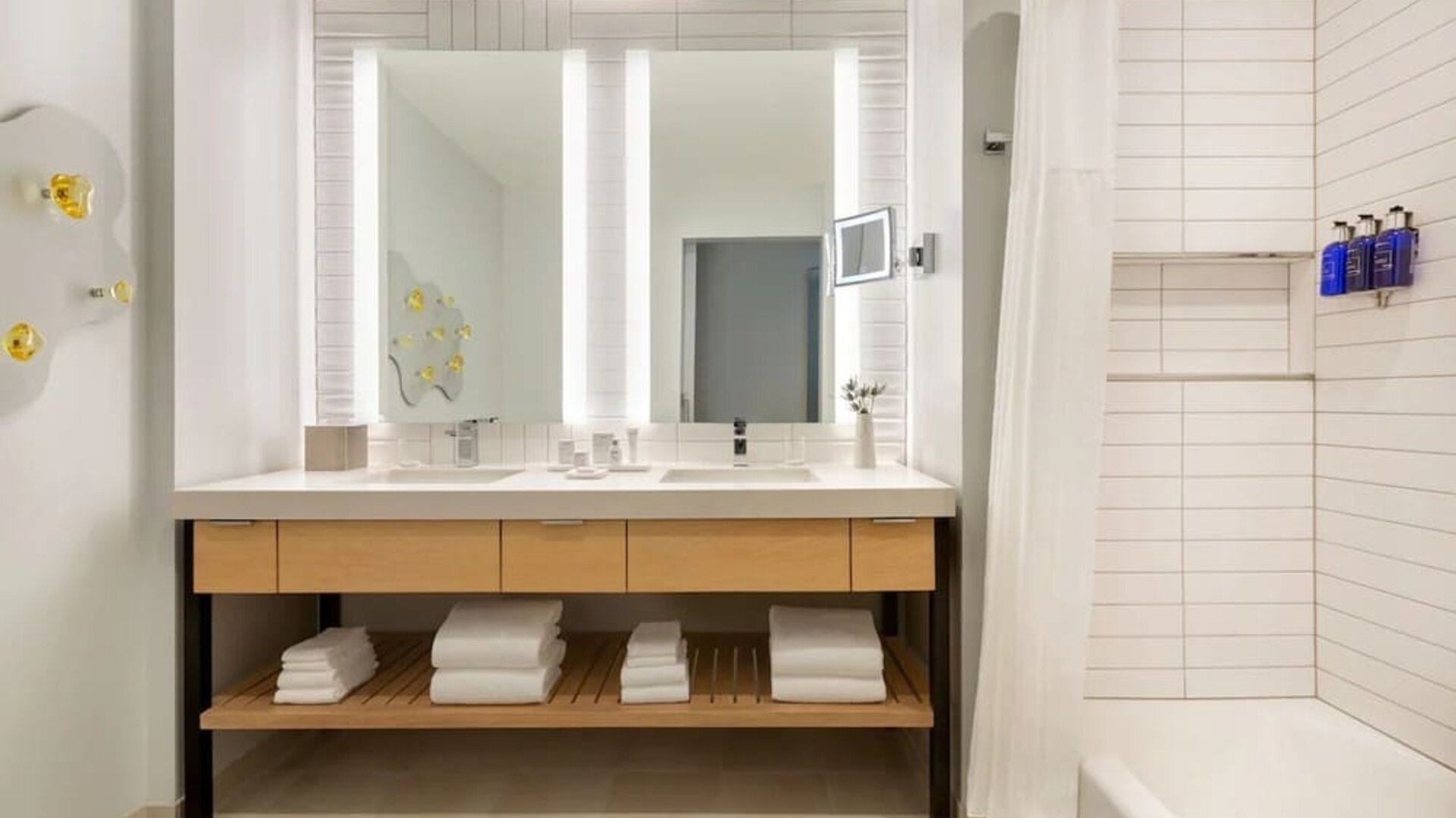 Guest bathroom with dual illuminated mirrors, spacious vanity, and modern bath amenities designed for comfort and convenience.