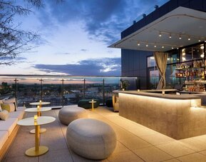 Rooftop bar and lounge with panoramic Anaheim views, stylish seating, ambient lighting, and an elegant setting for cocktails and evening gatherings.