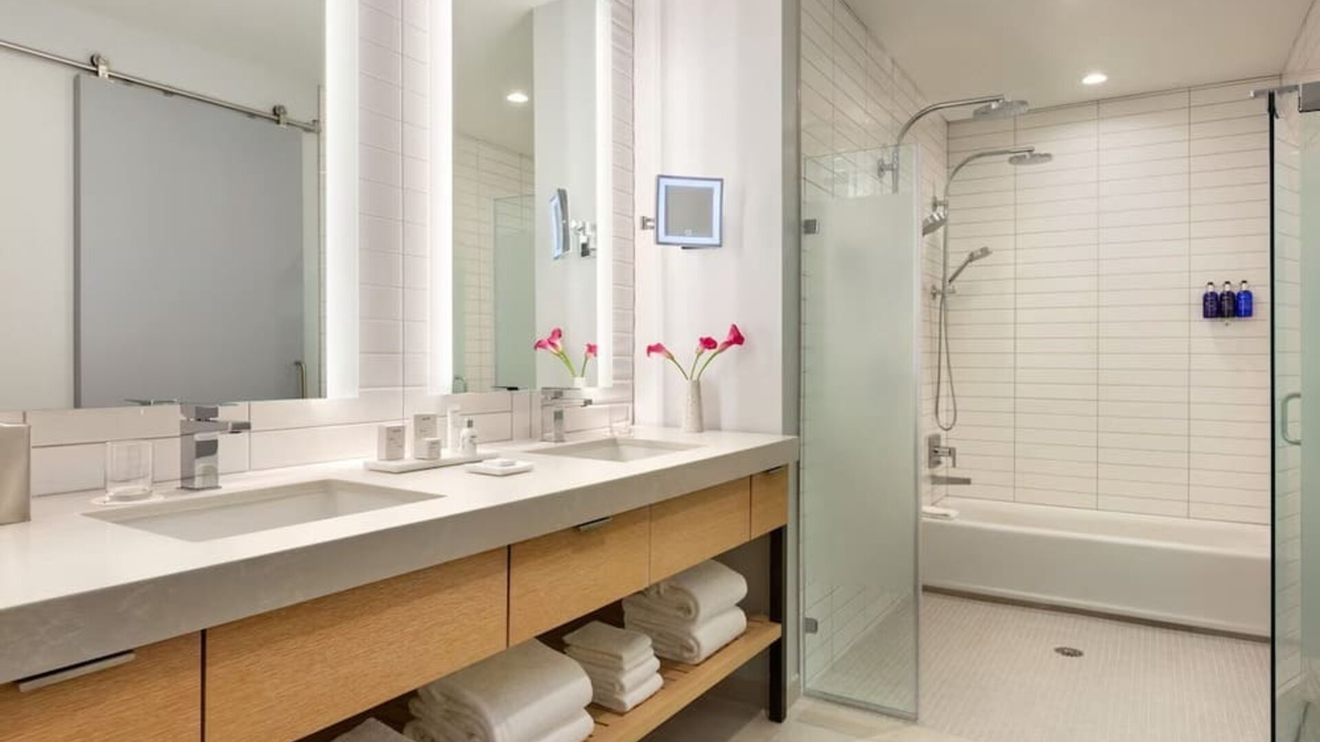 Large luxury bathroom with dual vanities, expansive mirrors, walk-in shower, soaking tub, and premium finishes designed for comfort and convenience.