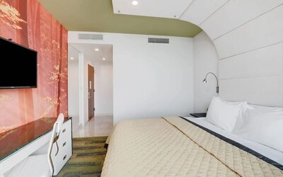 Stylish king bedroom with contemporary décor, plush bedding, work desk, flat-screen television, and thoughtfully designed interior finishes.