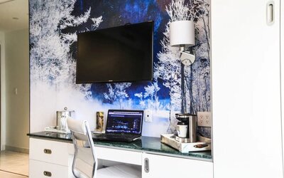 In-room workspace with desk, ergonomic seating, coffee station, storage cabinetry, and entertainment amenities ideal for business and leisure travelers.