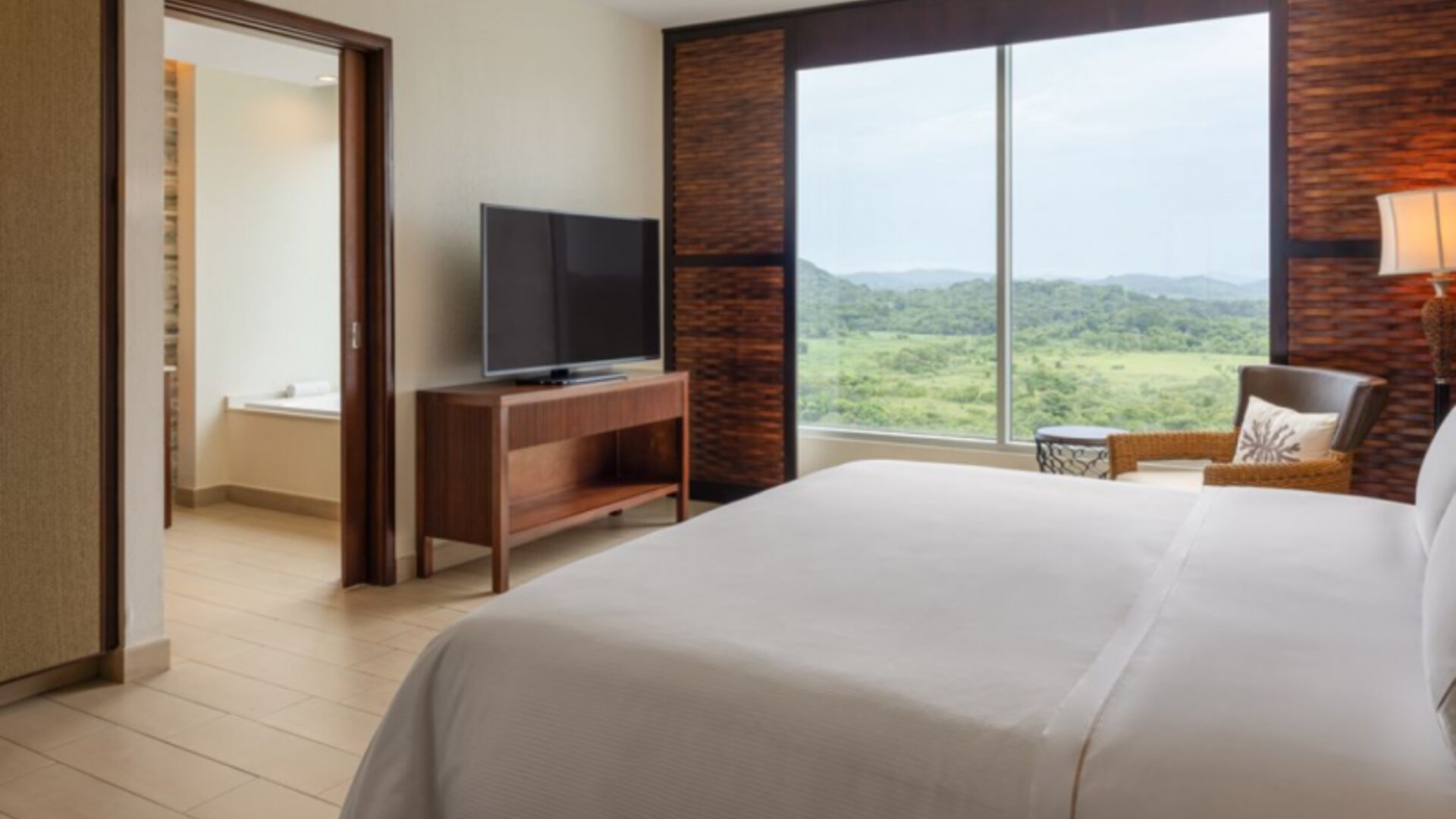 Deluxe King Room with Ocean View, featuring a private bathroom with amenities, a king-size bed, a safe, a desk, a telephone, ironing facilities, a kettle, a coffee maker, a hairdryer, cable TV, and an alarm clock.