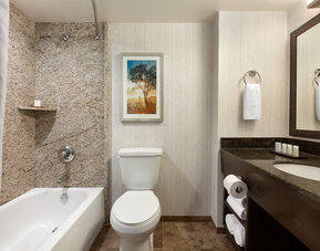 Guest bathroom with shower and tub at Embassy Suites By Hilton Brea North Orange County.