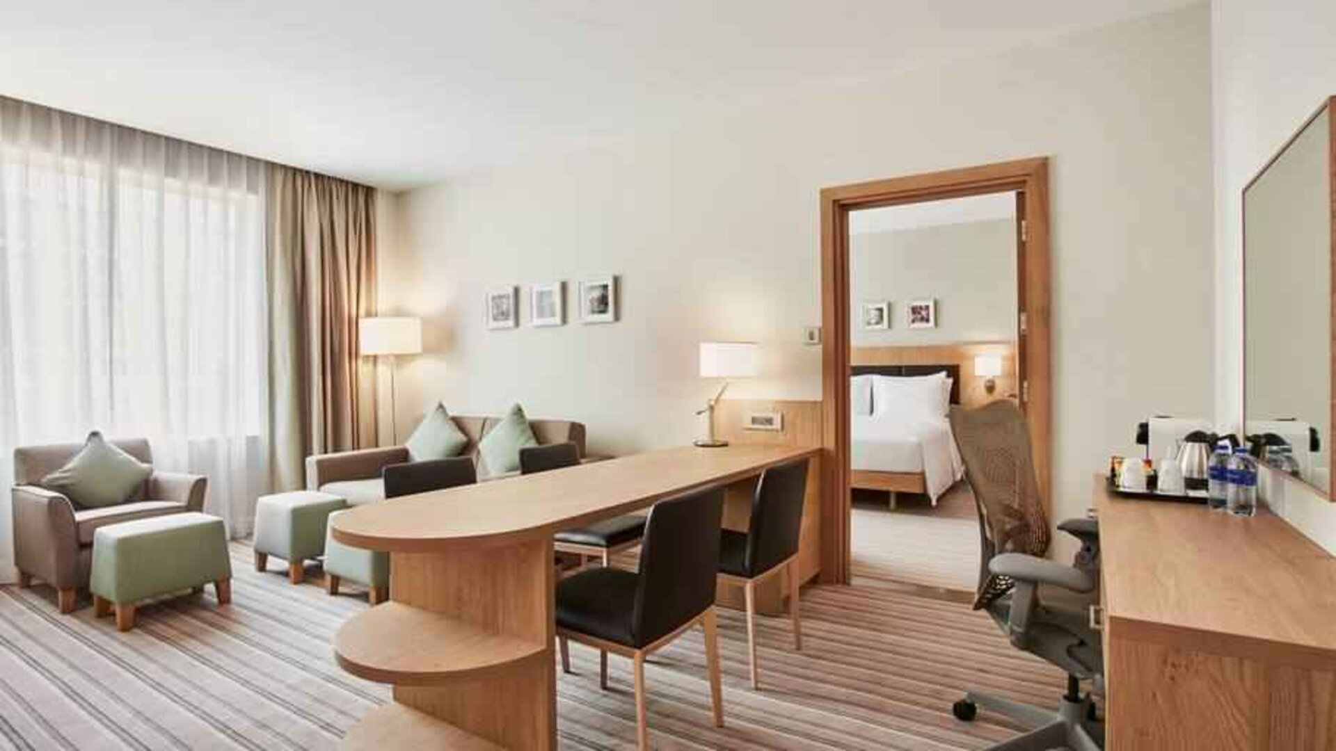 King bedroom suite with living room, sofa bed and working station at the Hilton Garden Inn Dubai Mall of the Emirates.