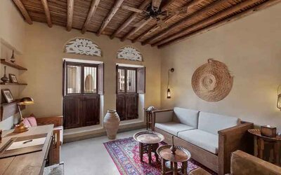 Spacious living room with sofa, TV screen and desk at the Al Seef Heritage Hotel Dubai, Curio Collection by Hilton.