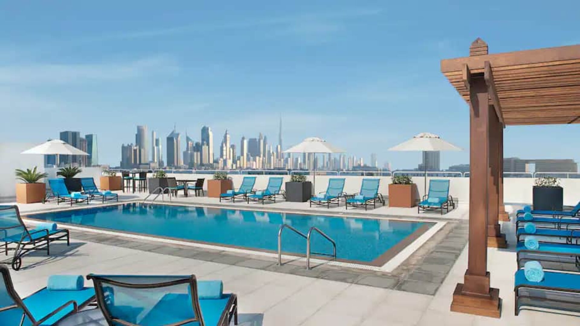Beautiful outdoor pool with deck and pool chairs at the Hilton Garden Inn Dubai Al Mina