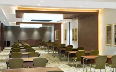 Large meeting room and workspace with multiple chairs and desks at the Hilton Garden Inn Dubai Al Muraqabat