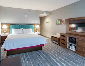 Comfortable king bed in a hotel room at the Hampton Inn Madison, OH.