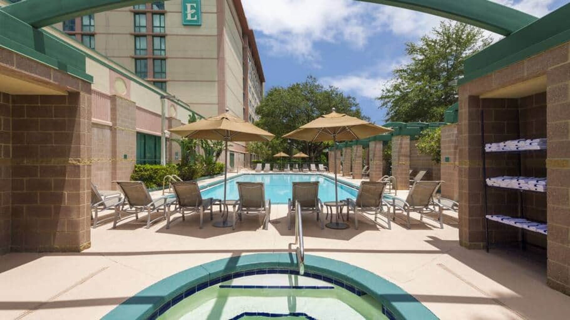 Beauitful outdoor pool with pool chairs and small jacuzzi at the Embassy Suites by Hilton Tampa USF