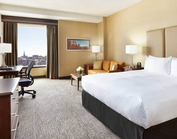 King room with 1 king bed, work desk and view of downtown at the Hilton Saint John.