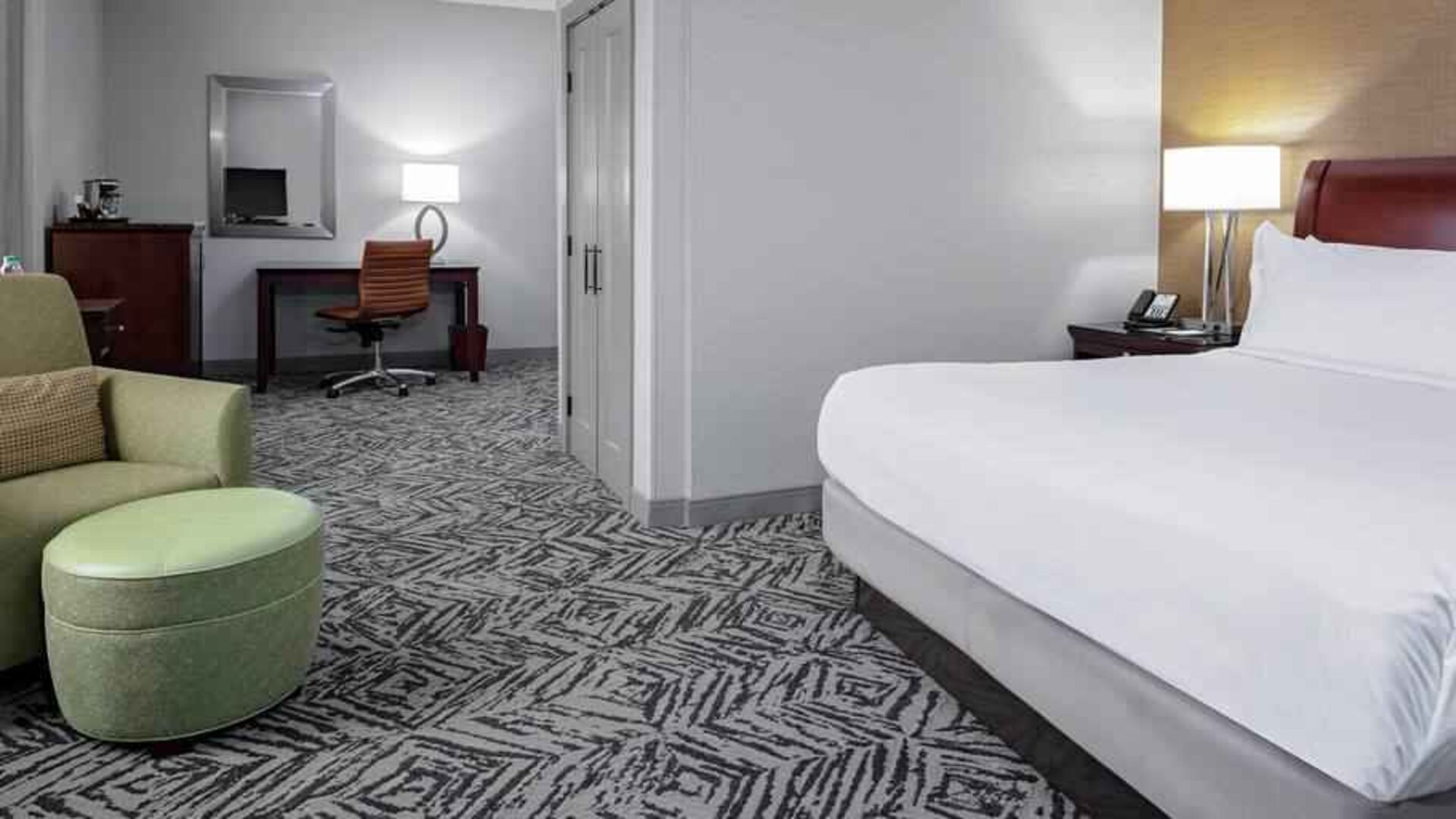 Comfortable king suite with desk and sofa at the DoubleTree by Hilton Omaha-Downtown.