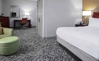 Comfortable king suite with desk and sofa at the DoubleTree by Hilton Omaha-Downtown.