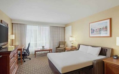 King size bed, desk and TV screen in a hotel room at the Hilton Seattle Airport & Conference Center.