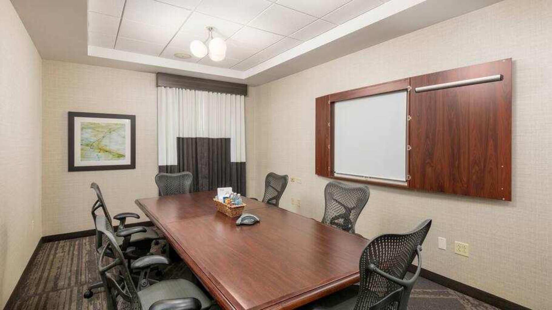Small meeting room with screen at the Hilton Garden Inn Silver Spring White Oak.