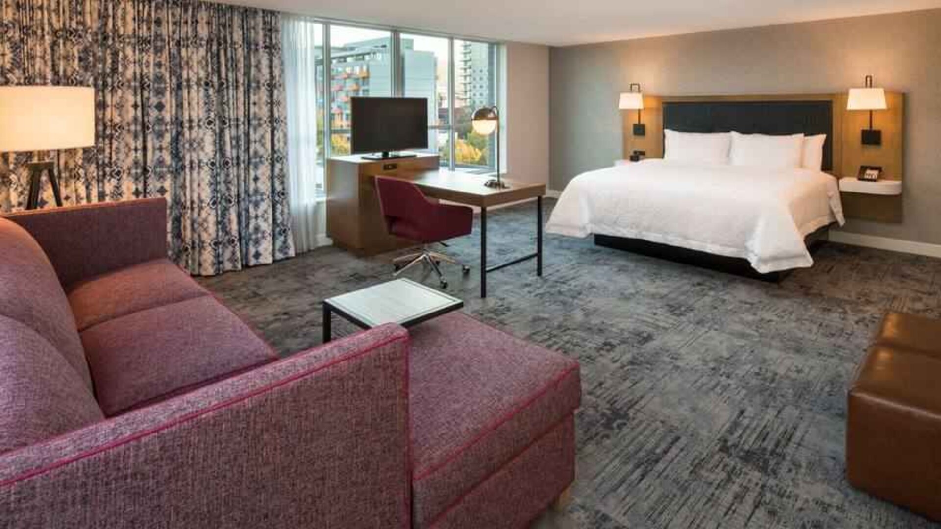King bedroom with sofa and desk at the Hampton Inn & Suites by Hilton Portland-Pearl District.