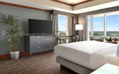 President suite with king size bed, desk and view at the Hilton Baltimore BWI Airport.