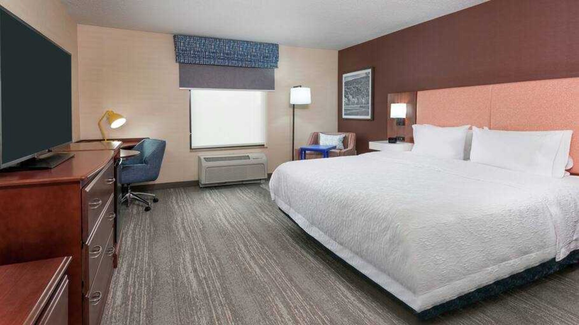 Spacious king bedroom with desk and TV screen at the Hampton Inn Springfield South Enfield.