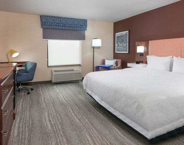 Spacious king bedroom with desk and TV screen at the Hampton Inn Springfield South Enfield.