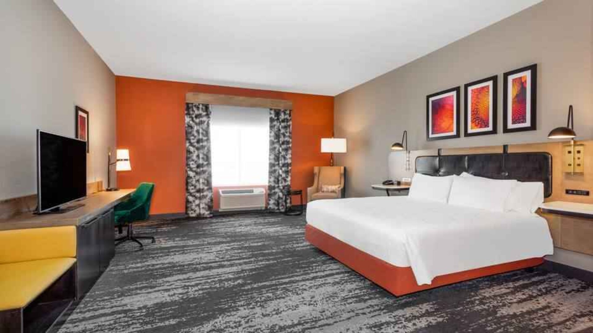 Spacious and comfortable king bedroom with window and TV screen at the Hilton Garden Inn Hays.