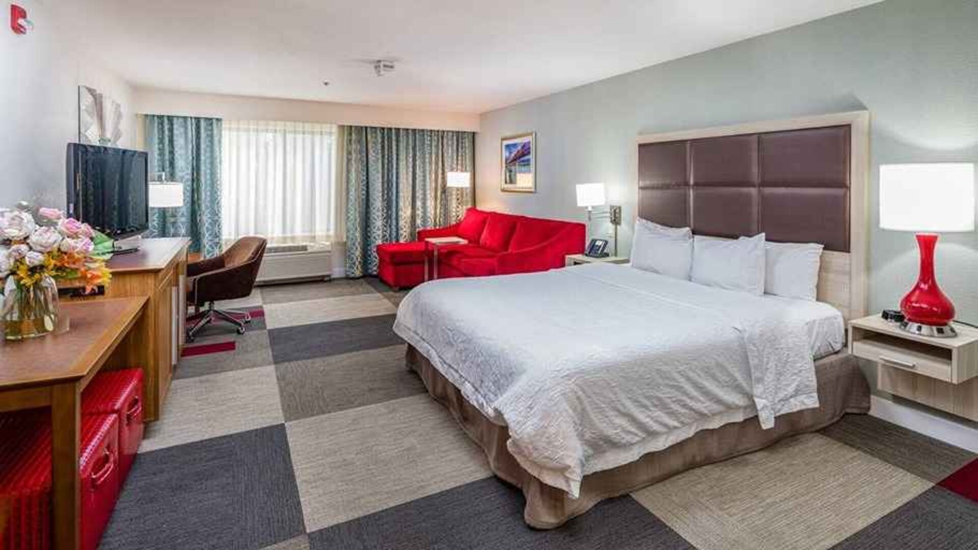 Spacious king room with work area and lounge at Hampton Inn San Francisco Airport.