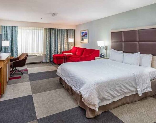 Spacious king room with work area and lounge at Hampton Inn San Francisco Airport.