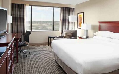 Bright and comfortable king bedroom with window at the DoubleTree by Hilton Kansas City - Overland Park.