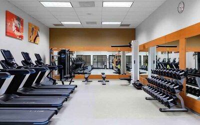 Fitness center with treadmills and weights at the DoubleTree by Hilton Kansas City - Overland Park.