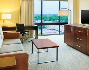 Living area with sofa and desk in a king suite at the Hilton San Antonio-Airport.