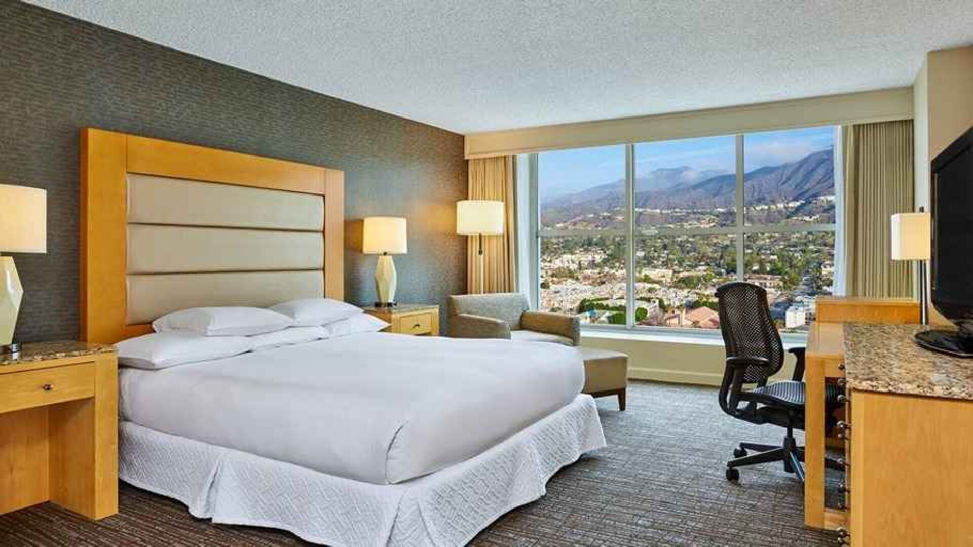 spacious king suite with natural light and work desk at Hilton Los Angeles North/Glendale & Executive Meeting Ctr.