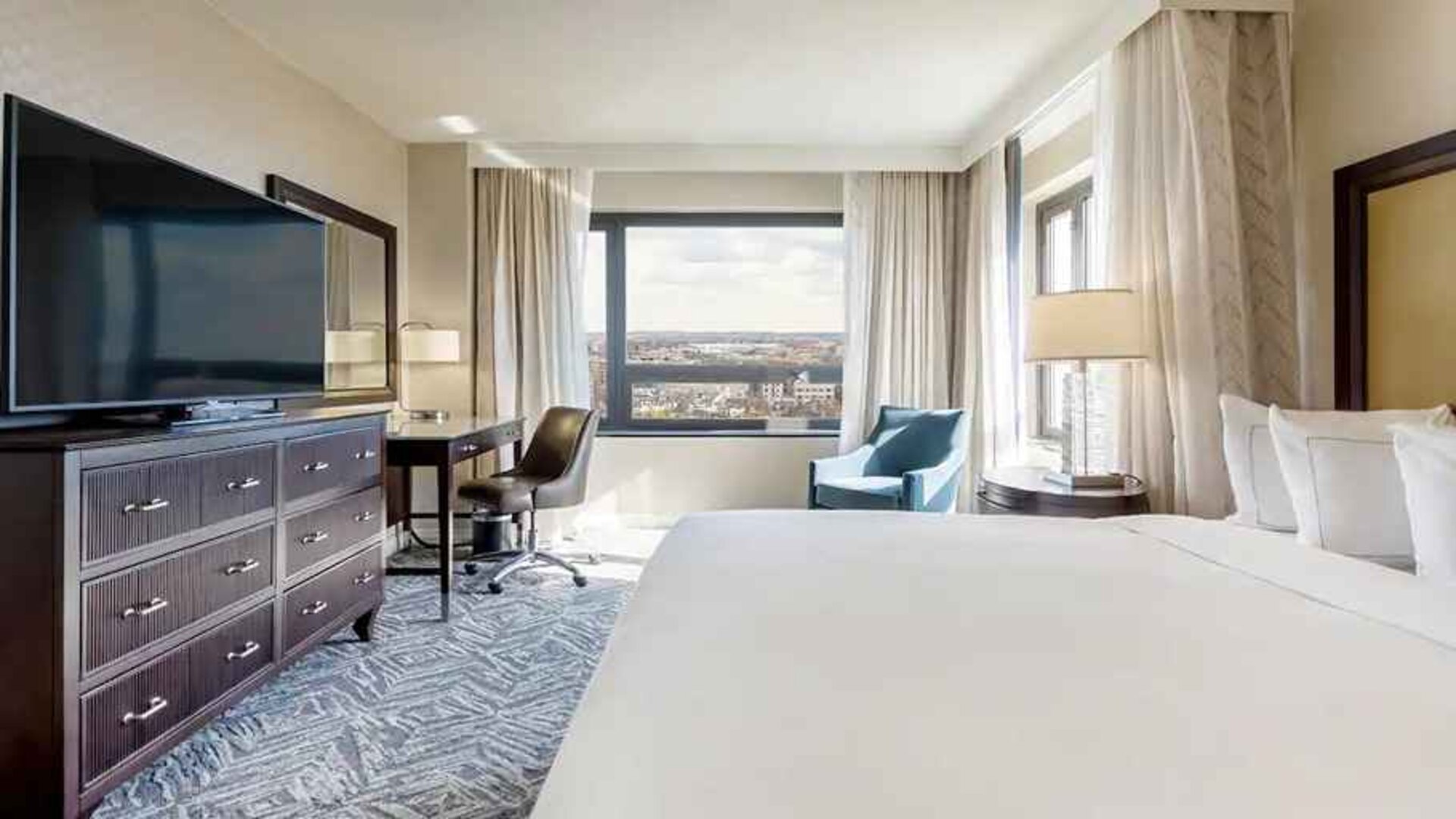 beautiful king room with work desk, TV, and natural light at Washington Hilton.