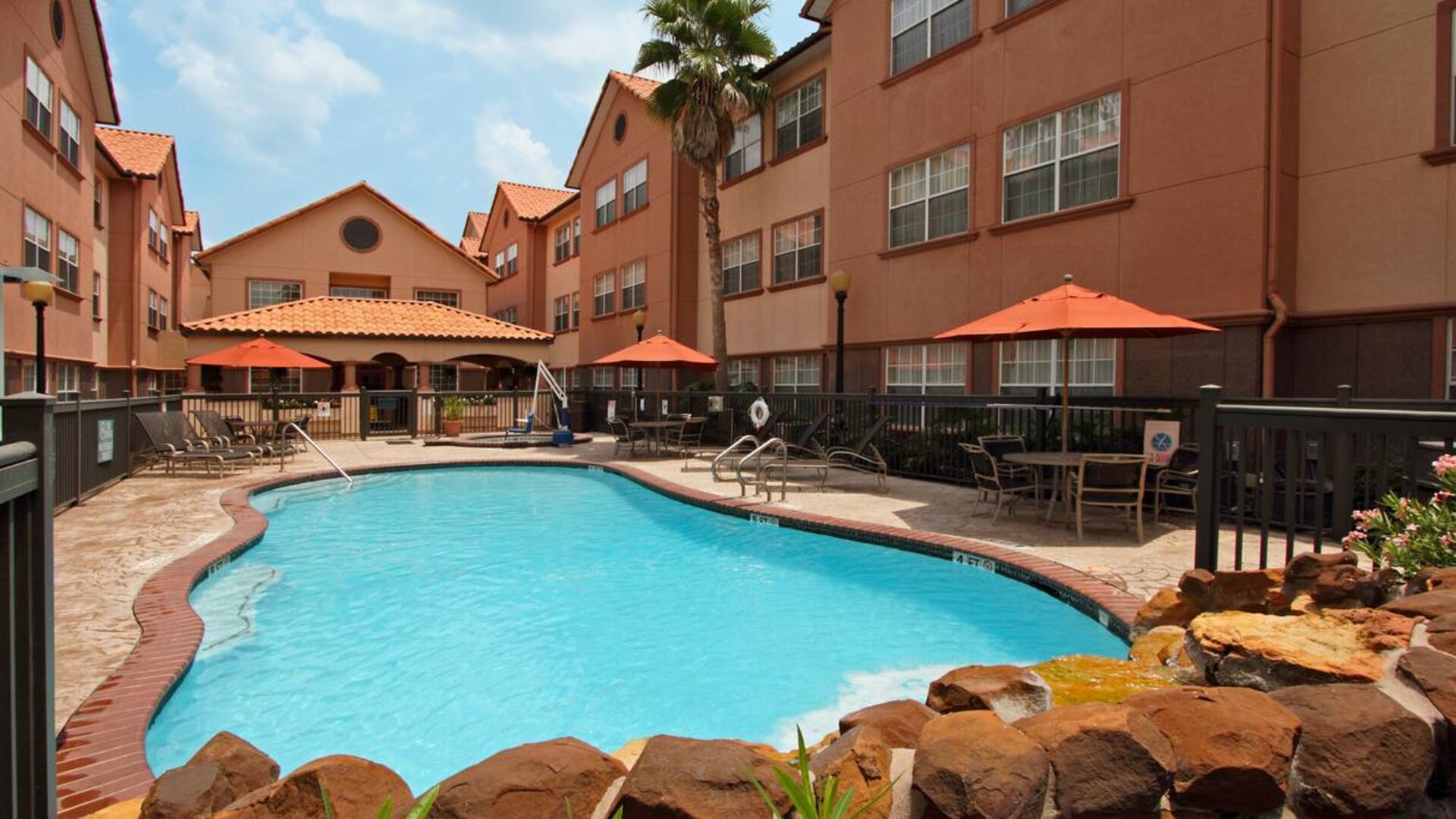 beautiful outdoor pool with sun beds and seating area at Homewood Suites by Hilton Houston-Woodlands.