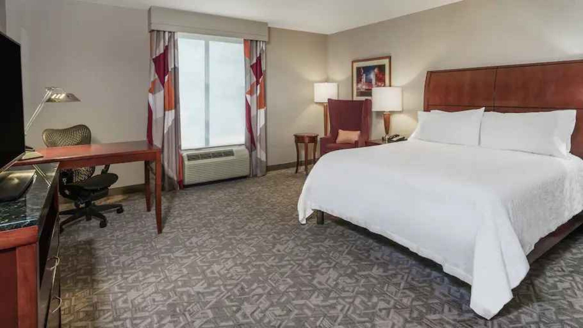 King size bed and desk in a hotel bedroom at the Hilton Garden Inn Blacksburg University.