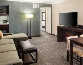 Spacious and comfortable hotel living room with sofa and desk at the Embassy Suites by Hilton Tysons Corner.