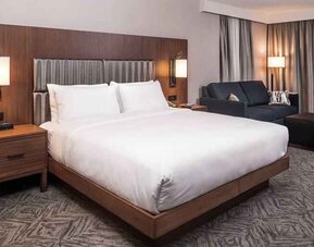 Spacious king bedroom with king size bed and sofa at the DoubleTree by Hilton Lafayette East.