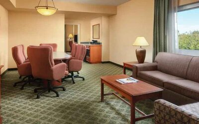 Spacious living room with working station in a hotel suite at the Embassy Suites by Hilton Charleston Airport Convention Center.