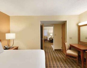 King suite with TV screen and desk at the Embassy Suites by Hilton Greenville Golf Resort Conference Center