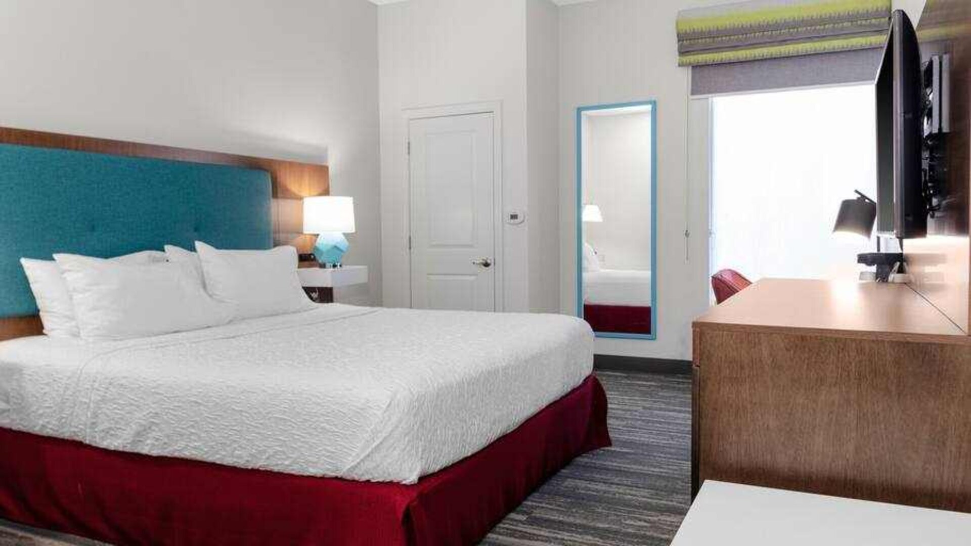 King bedroom with TV screen and window at the Hampton Inn Concord Bow.