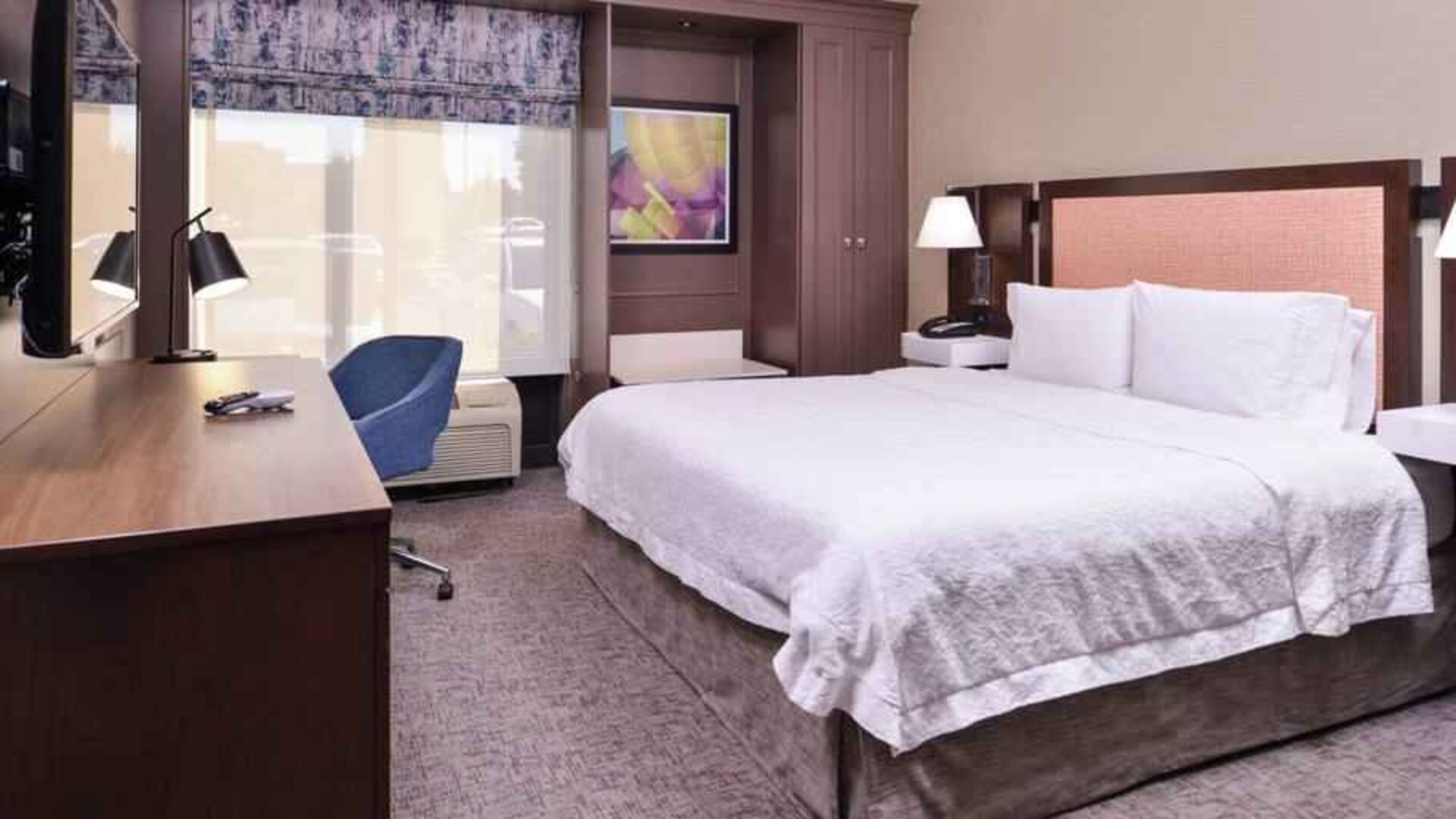 Comfortable king size bed in a hotel room at the Hampton Inn Albuquerque, University-Midtown (UNM).