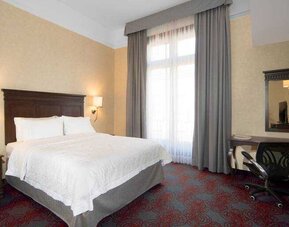 Bright king bedroom with desk and window at the Hampton Inn & Suites Mexico City - Centro Historico.