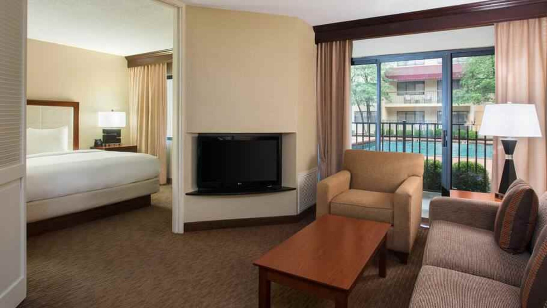 Hotel suite with king size bed, sofa and pool view at the DoubleTree Suites by Hilton Cincinnati-Blue Ash.