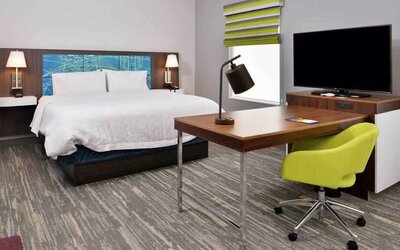 Working station in a hotel room with king size bed at the Hampton Inn & Suites St. Paul Oakdale/Woodbury by Hilton.