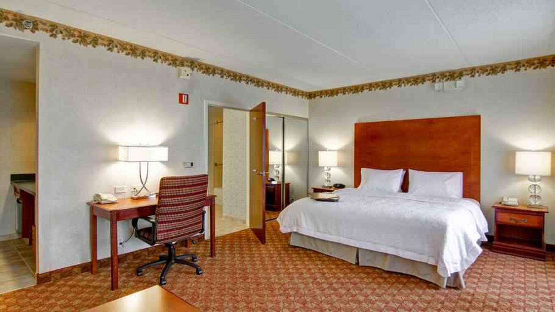 King bedroom with desk at the Hampton Inn & Suites Leesburg.