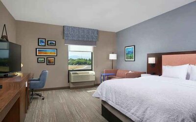 King bedroom with desk, window and sofa at the Hampton Inn Burley.