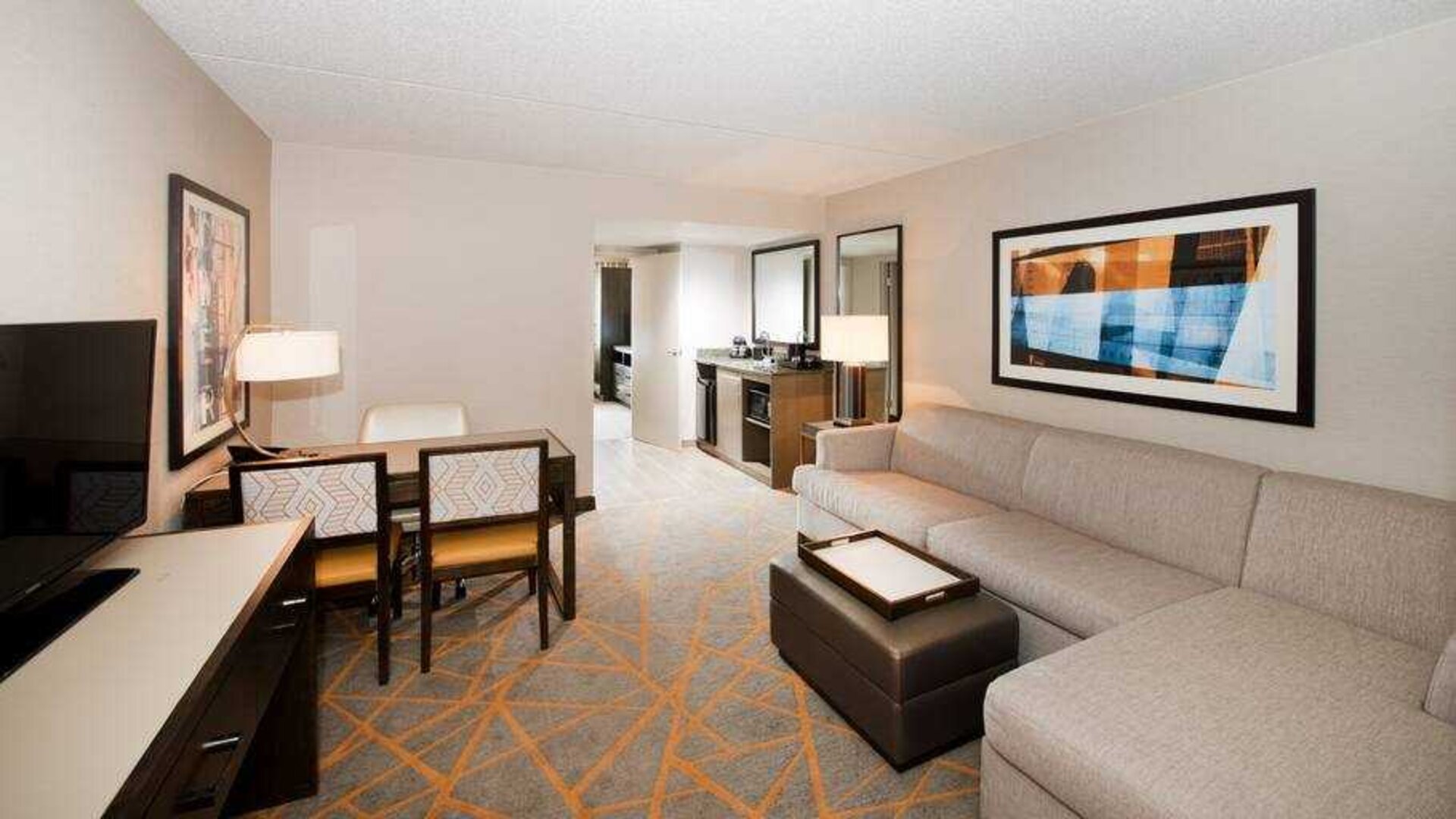 Living room with working station in a hotel suite at the Embassy Suites by Hilton Cincinnati Blue Ash.