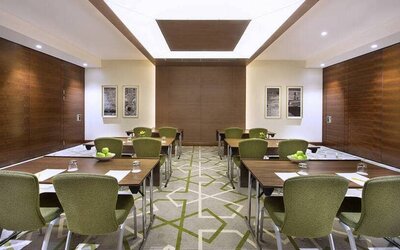Large coworking or conference meeting room with six tables of four seats each,