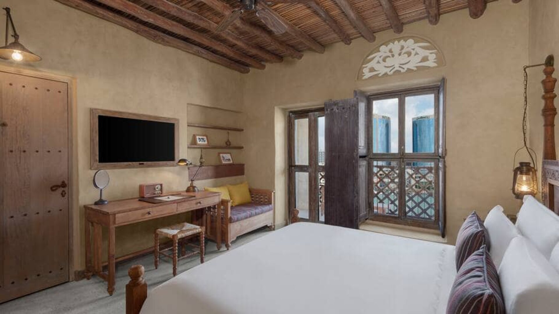 King bed with large TV and spacious workstation at the Al Seef Heritage Hotel Dubai, Curio Collection by Hilton.