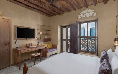 King bed with large TV and spacious workstation at the Al Seef Heritage Hotel Dubai, Curio Collection by Hilton.