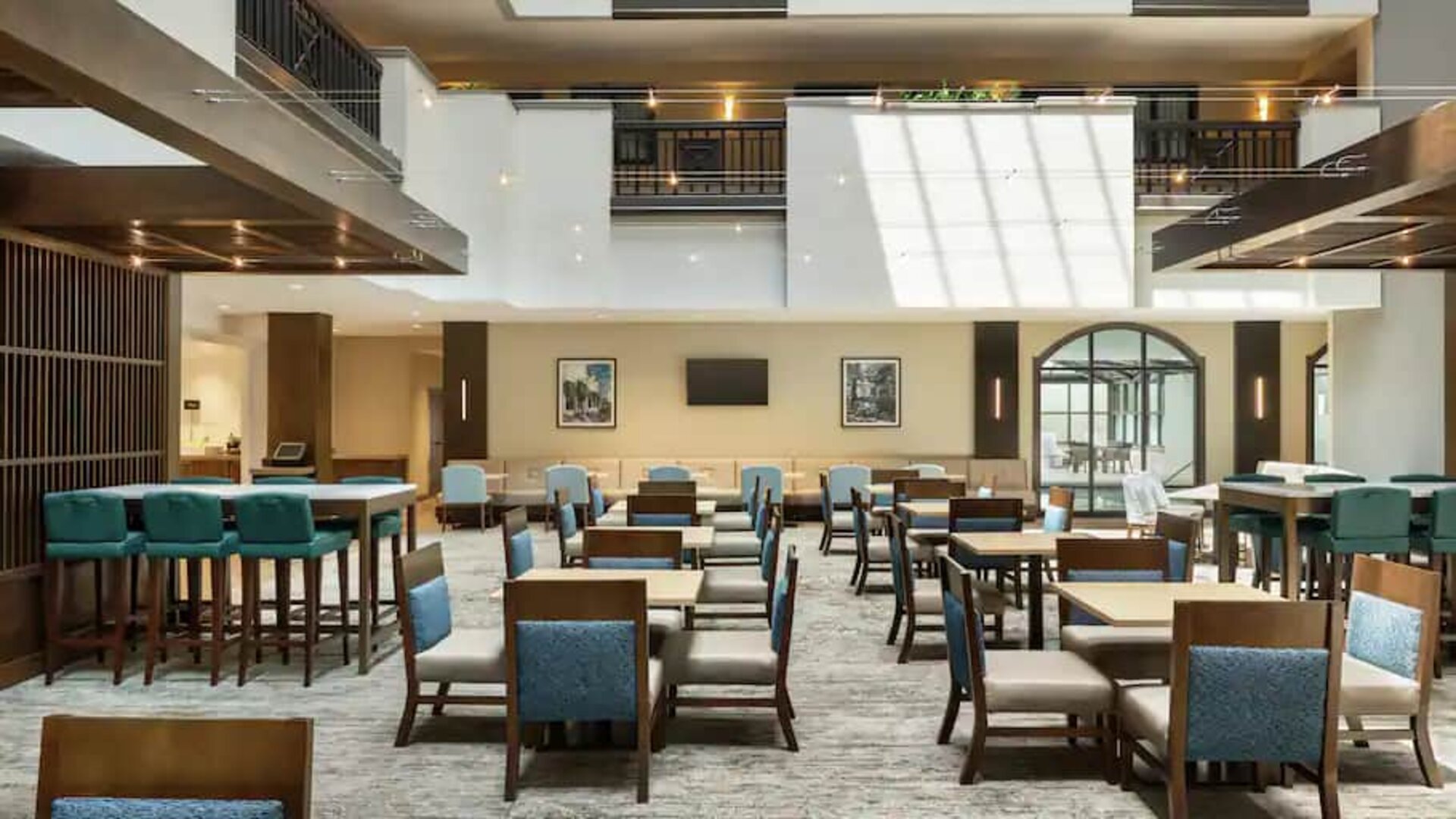 Center of hotel filled with natural light, spacious tables to sit and chat or be productive working.