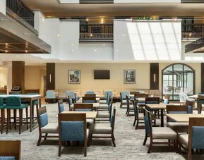 Center of hotel filled with natural light, spacious tables to sit and chat or be productive working.